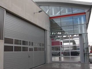 Puerta Industrial Puerta Seccional Hörmann con panel acristalado con climalit y puerta peatonal incorporada